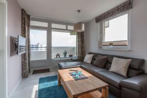 a living room with a couch and a table at Christiansen im Panoramahaus Duhnen in Cuxhaven