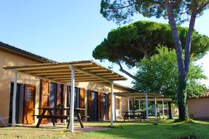 a pavilion with a picnic table in front of a house at Agriturismo Arundineto Valle - by Bolgheri Holiday in Castagneto Carducci