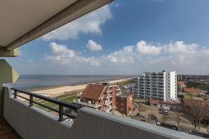 uma varanda com vista para a praia e para os edifícios em Christiansen im Panoramahaus Duhnen em Cuxhaven