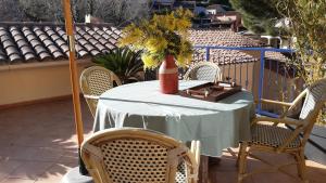a table with chairs and a vase with flowers on it at Maison Croisette in Sainte-Maxime