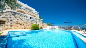 une piscine en face d'un bâtiment dans l'établissement Ilios Village, à Stalós