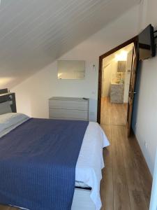 Un dormitorio con una cama azul y un pasillo en RESIDENZA VILLA LEONIDA, en SantʼAmbrogio di Valpolicella