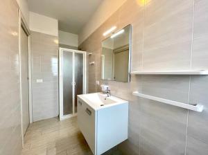a bathroom with a white sink and a mirror at Residence Treporti - Carraro Immobiliare - Family Apartments in Cavallino-Treporti