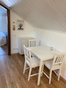 Una mesa blanca y sillas en una habitación con cama en RESIDENZA VILLA LEONIDA, en SantʼAmbrogio di Valpolicella
