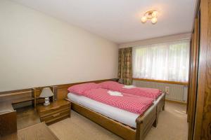 a bedroom with a bed with a red blanket at Ferienwohnung Kurhaus in Adelboden