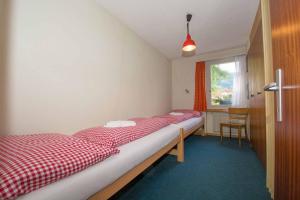 1 dormitorio con 2 camas y ventana en Ferienwohnung Kurhaus en Adelboden