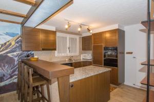 a kitchen with wooden cabinets and a counter top at Ferienwohnung Kurhaus in Adelboden