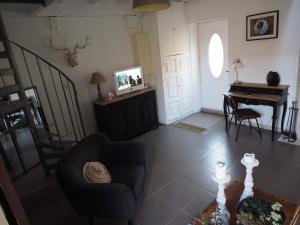 a living room with a couch and a piano at La Cuvée-Saint-Georges in Nuits-Saint-Georges