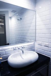 a white bathroom with a sink and a mirror at Casa Patrones in Chiclayo +25 photos