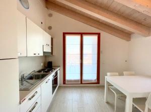 a kitchen with white cabinets and a table at Residence Treporti - Carraro Immobiliare - Family Apartments in Cavallino-Treporti +22 photos