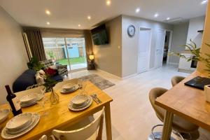 comedor y sala de estar con mesa y sillas en Modern and spacious open plan bungalow, en Felixstowe