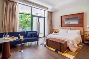 una camera d'albergo con un letto e un divano blu di The Quorum a Lusaka
