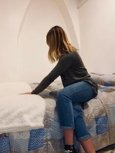 a woman sitting on top of a bed at casa laurel in Meta