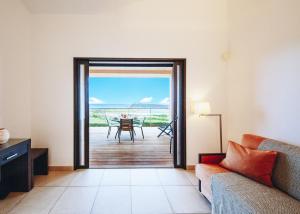 a living room with a door leading to a patio at Résidence Les Terrasses de Rondinara in Bonifacio
