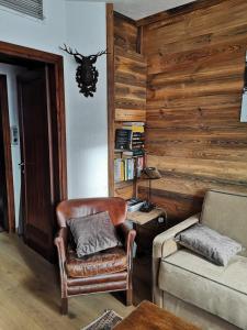 een woonkamer met een stoel en een bank bij Appartamento in Madonna di Campiglio