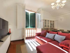 a living room with a red couch and a television at UR-NEST Montegrappa in Bologna