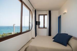 a bedroom with a bed and a large window at B&B Villa Ziella in Portopalo
