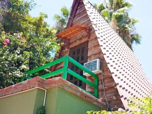 un balcón verde en la parte superior de una casa en Cabañas Rústicas El Benny by Rotamundos, en Loreto