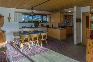 eine Küche mit einem Tisch und Stühlen im Zimmer in der Unterkunft El Cantun - 7 Zimmer Einfamilienhaus mit 200m2 in Flims