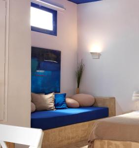 キモロスにあるPsathi Blue Betaの窓付きの客室で、青いソファが備わります。