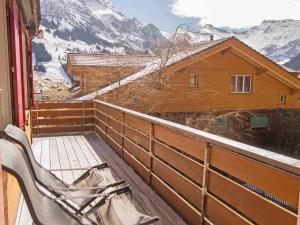 a chair on a balcony with a view of a mountain at Chalet Azeno OG in Adelboden