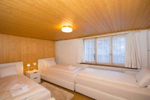 - une chambre avec 2 lits et une fenêtre dans l'établissement Chalet Pavillon, à Adelboden