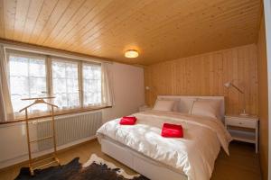 アデルボーデンにあるChalet Pavillonのベッドルーム1室(赤い枕2つ付)