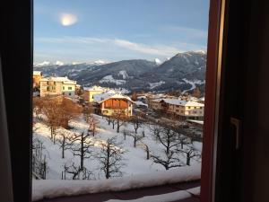 a view of a city in the snow from a window at Albergo Dolomiti in Cavalese