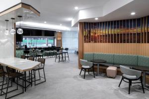 um restaurante com mesas e cadeiras e um bar em Hyatt Place Tempe Phoenix University em Tempe