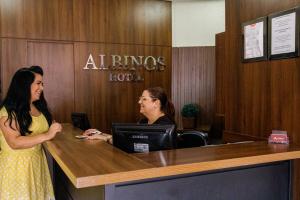 two women sitting at a desk in an office at Hotel Albinos in Itaperuna