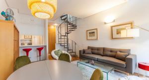 ein Wohnzimmer mit einem Sofa und einem Tisch in der Unterkunft Apartamento Barquillo Duplex en Madrid in Madrid