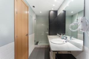 łazienka z dwiema umywalkami i prysznicem w obiekcie Apartamento Barquillo Duplex en Madrid w Madrycie