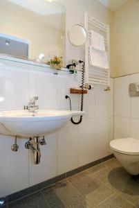 uma casa de banho com um lavatório e um WC em Just Sleep Trier em Trier