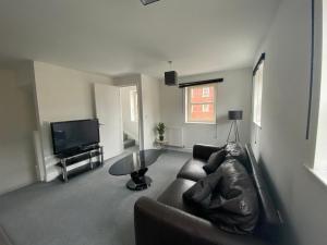 ein Wohnzimmer mit Sofa und Tisch in der Unterkunft Doncaster Furnished House For Short Lets in Mexborough