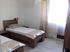 a small bedroom with two beds and a window at PENSIUNEA AGROTURISTICĂ ANGHELIKI in Tulcea