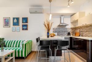 uma cozinha com um sofá riscado verde e branco em Apartment Spalatin em Split