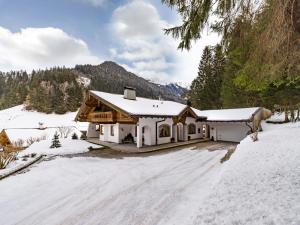 a house covered in snow with a snow covered driveway at Ferienwohnung Bacher Oberkumbichl 900 in Mayrhofen