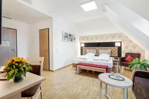 a bedroom with a bed and a living room at Hotel Rappen Rothenburg ob der Tauber in Rothenburg ob der Tauber +135 photos