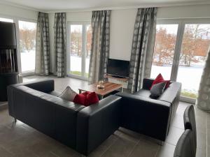 a living room with two couches and a flat screen tv at Ferienhaus am Schaalsee in Zarrentin