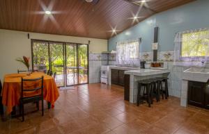 a large kitchen with a table and chairs in it at Cabañas Río Escondido en La Fortuna in Fortuna
