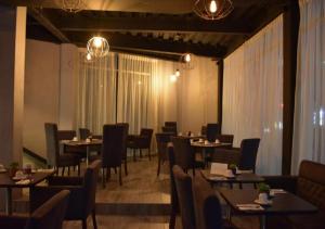 une salle à manger avec des tables, des chaises et des lumières dans l'établissement ESDUMA HK HOTEL Pachuca, à Pachuca