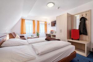 1 dormitorio con 2 camas y una maleta roja en Hotel Rappen Rothenburg ob der Tauber, en Rothenburg ob der Tauber