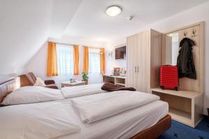 a bedroom with two beds and a red suitcase at Hotel Rappen Rothenburg ob der Tauber in Rothenburg ob der Tauber