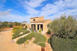 an old stone house with bushes in front of it at Finca Can Xesquet Camí de Morell 169 by Mallorca Charme in Ses Salines