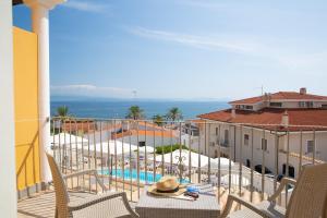 a beach scene with a balcony overlooking the ocean at Lu' Hotel Maladroxia in SantʼAntìoco