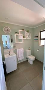 La salle de bains est pourvue de toilettes blanches et d'un lavabo. dans l'établissement Stay at the Point - Luxurious Lavish Looker, à Durban