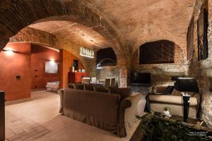 a living room with couches and a stone wall at Villa Guinigi Dimora di Epoca Exclusive Residence & Pool in Lucca