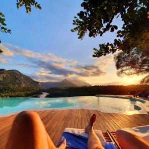 a person laying on a deck next to a swimming pool at Hotel Villa Cedrino in Dorgali
