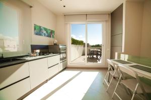kuchnia z białymi szafkami i widokiem na balkon w obiekcie Casa Angelina w mieście Marsala