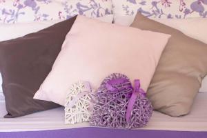 1 cama con 2 almohadas y un corazón púrpura y blanco en B&B La Corte della Nonna, en Samarate